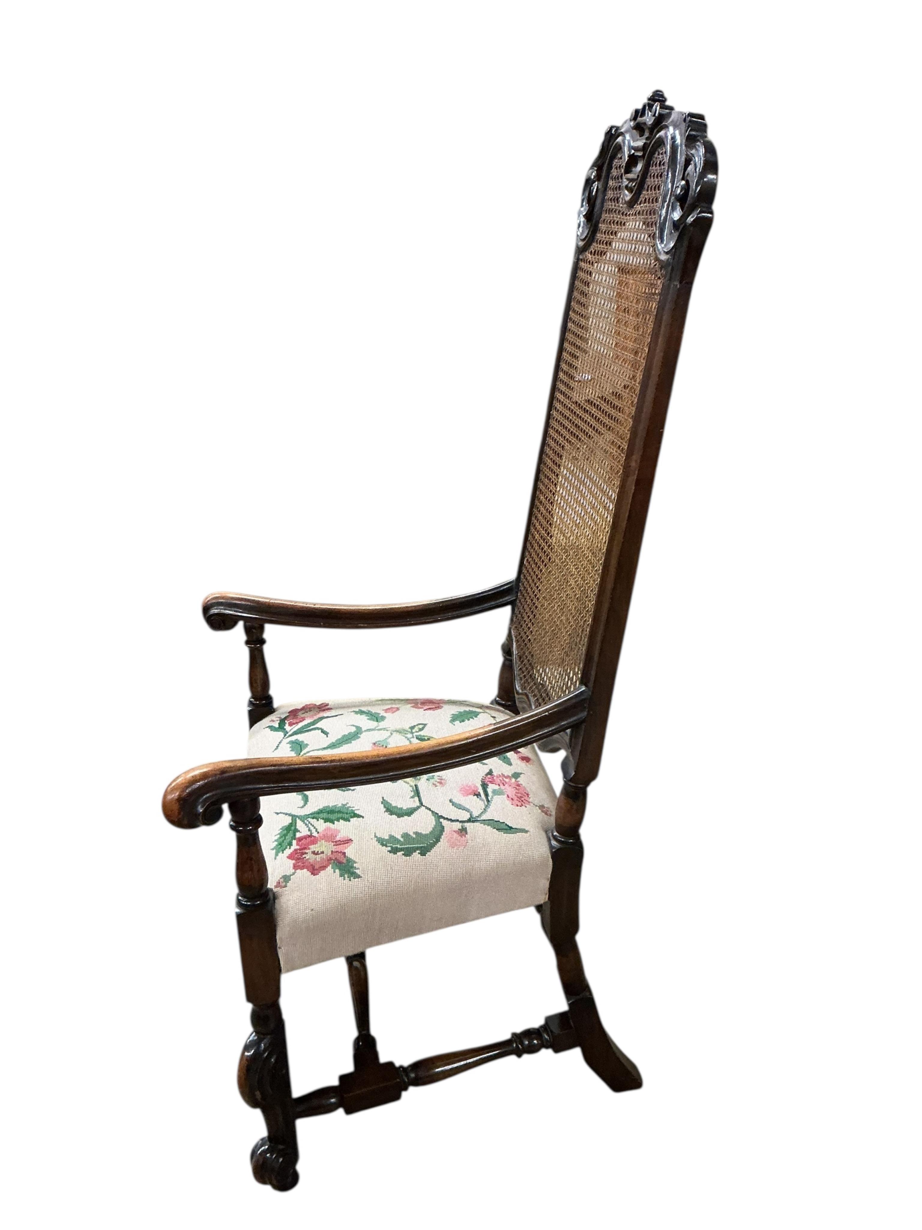 A Carolean style caned walnut high back elbow chair, width 65cm, depth 58cm, height 140cm